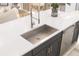 Close-up of a modern kitchen sink with stainless steel fixtures and a white countertop at 13181 Telsen St # 39, Winter Garden, FL 34787