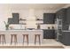 Modern kitchen featuring dark cabinets, a white island with bar seating, and stainless steel appliances at 13181 Telsen St # 39, Winter Garden, FL 34787