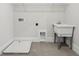 Bright laundry room features a utility sink, tile floor, and convenient overhead storage at 13181 Telsen St # 39, Winter Garden, FL 34787