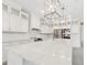 Beautiful kitchen with white cabinets, stainless steel appliances, a large island with quartz countertops, and pendant lighting at 13187 Telsen St # 38, Winter Garden, FL 34787