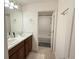 Bright bathroom featuring double sinks with a view into the tiled shower and tub at 14533 Crestavista Ave, Clermont, FL 34714