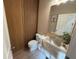 Contemporary half-bathroom with an illuminated marble sink, wood paneling, and modern fixtures at 14533 Crestavista Ave, Clermont, FL 34714