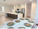 Open-concept kitchen featuring stainless steel appliances, modern lighting, and a breakfast bar with seating at 14533 Crestavista Ave, Clermont, FL 34714