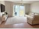 Cozy living room with wood floors, a plush sofa, and sliding glass doors to the patio at 14533 Crestavista Ave, Clermont, FL 34714