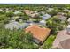 Aerial view of a single-Gathering home on a tree-lined street with well-maintained landscaping and neighborhood at 187 Tall Pines Pass, Kissimmee, FL 34759