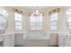 Bright bathroom with double sinks, white cabinets, garden tub, and decorative lighting fixtures at 187 Tall Pines Pass, Kissimmee, FL 34759