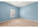 Bright bedroom with blue walls, neutral carpet, and a window with plantation shutters at 187 Tall Pines Pass, Kissimmee, FL 34759