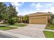 Charming home with a well-manicured lawn, lush landscaping, and a brick driveway at 187 Tall Pines Pass, Kissimmee, FL 34759