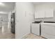Bright laundry room with washer, dryer, and built-in cabinets at 187 Tall Pines Pass, Kissimmee, FL 34759