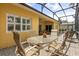 Outdoor patio area featuring a brick floor, screened-in enclosure, and comfortable seating arrangements at 187 Tall Pines Pass, Kissimmee, FL 34759