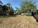 Spacious backyard featuring mature trees, a lawn, and a white picket fence at 1931 N Portillo Dr, Deltona, FL 32738