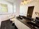 Bathroom featuring a white cabinet, dual sinks, black countertop, and black marble floors at 1931 N Portillo Dr, Deltona, FL 32738