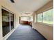 Enclosed porch or sunroom with carpet, ceiling fan, storage and access to the outside at 1931 N Portillo Dr, Deltona, FL 32738
