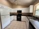 Well-lit kitchen with white cabinets, dark countertops, tile floors, and modern appliances at 1931 N Portillo Dr, Deltona, FL 32738