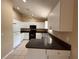 Modern kitchen with white cabinets, dark countertops, stainless steel sink, tile floor and eat-in bar area at 1931 N Portillo Dr, Deltona, FL 32738