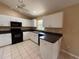 Bright kitchen featuring white cabinets, black appliances, tile flooring, and lots of storage at 1931 N Portillo Dr, Deltona, FL 32738