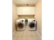 Bright laundry room featuring a modern washer and dryer, plus storage cabinets above appliances at 1931 N Portillo Dr, Deltona, FL 32738