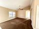 Open living area featuring carpeting, neutral paint, ceiling fan, and entry to the kitchen at 1931 N Portillo Dr, Deltona, FL 32738
