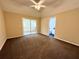 Carpeted main bedroom with sliding glass doors to the back porch and access to ensuite bathroom at 1931 N Portillo Dr, Deltona, FL 32738