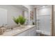 Bathroom featuring double sinks with a white vanity, large mirror, and walk-in shower at 2064 Monteverde Ave, Davenport, FL 33837