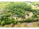 Aerial view of a large lot with mature landscaping and views of other nearby homes and trees in the distance at 2320 Red Ember Rd, Oviedo, FL 32765