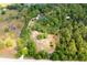Overhead view of a secluded property with large trees and foliage and nearby homes and buildings in the distance at 2320 Red Ember Rd, Oviedo, FL 32765