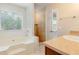 Bathroom with a tub under a window with blinds and a vanity with dark cabinets at 2320 Red Ember Rd, Oviedo, FL 32765