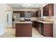 Well-equipped kitchen with stainless steel appliances, dark wood cabinets, and tile flooring at 2320 Red Ember Rd, Oviedo, FL 32765