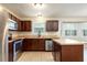 Spacious kitchen with stainless steel appliances, dark wood cabinets, tile flooring, and bay window at 2320 Red Ember Rd, Oviedo, FL 32765