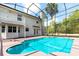 Back exterior view of screened-in turquoise pool and outdoor living space at 2320 Red Ember Rd, Oviedo, FL 32765