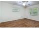 Bedroom with wood-look flooring, two windows, and a ceiling fan at 2350 Worthington Rd, Maitland, FL 32751