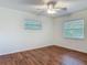 Bedroom featuring two windows, wood-look flooring, and a ceiling fan at 2350 Worthington Rd, Maitland, FL 32751