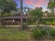 Beautiful brick home featuring lush landscaping, mature trees, and an inviting entrance at sunset at 2350 Worthington Rd, Maitland, FL 32751
