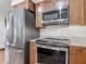 Modern kitchen featuring stainless steel appliances and wooden cabinets with granite countertops at 2350 Worthington Rd, Maitland, FL 32751