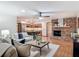 Cozy living room with brick fireplace open to a stylish kitchen with an island and stainless appliances at 2350 Worthington Rd, Maitland, FL 32751