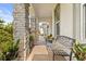 Covered front porch with stone columns, bench seating and decorative plants at 2431 Knoll Dr, Apopka, FL 32712