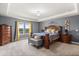 Large main bedroom featuring a tray ceiling, natural light, and plenty of space at 2431 Knoll Dr, Apopka, FL 32712