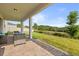 Covered brick patio featuring comfortable seating and an appealing view of the green backyard at 2431 Knoll Dr, Apopka, FL 32712