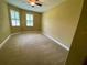 Spacious bedroom with carpet flooring, two windows, and a ceiling fan at 30732 Lipizzan Ter, Mount Dora, FL 32757