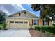 Inviting home exterior featuring a spacious garage, manicured lawn, and charming architectural details at 30732 Lipizzan Ter, Mount Dora, FL 32757