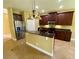 Spacious kitchen featuring dark wood cabinets, granite countertops, and stainless steel appliances at 30732 Lipizzan Ter, Mount Dora, FL 32757