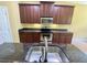 Bright kitchen with granite countertops, stainless steel oven, and dark wood cabinets at 30732 Lipizzan Ter, Mount Dora, FL 32757