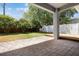 Serene backyard featuring a brick patio, a small wooden deck, and manicured shrubs at 3436 Gerber Daisy Ln, Oviedo, FL 32766