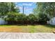 Well-maintained backyard with lush greenery, trees, and a partial view of a brick-lined fence at 3436 Gerber Daisy Ln, Oviedo, FL 32766