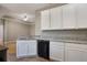 Kitchen featuring white cabinets, granite countertops, a stainless steel sink and black dishwasher at 3436 Gerber Daisy Ln, Oviedo, FL 32766