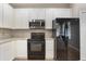 This kitchen features white cabinets, a black oven and refrigerator, and stainless steel microwave at 3436 Gerber Daisy Ln, Oviedo, FL 32766