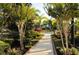 Professionally landscaped grounds feature a path leading to the pool surrounded by lush greenery and manicured hedges at 3436 Gerber Daisy Ln, Oviedo, FL 32766