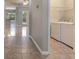 Convenient laundry room featuring a washer and dryer, shelving and tile floors, adjacent to the entry hall at 3436 Gerber Daisy Ln, Oviedo, FL 32766