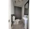 Small half-bath featuring gray accent wall, pedestal sink, and wood-framed mirror at 3463 Fekany Pl, Orlando, FL 32805