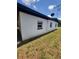 Shows the side of the house with white brick and black trim and a satellite dish on the roof at 3463 Fekany Pl, Orlando, FL 32805